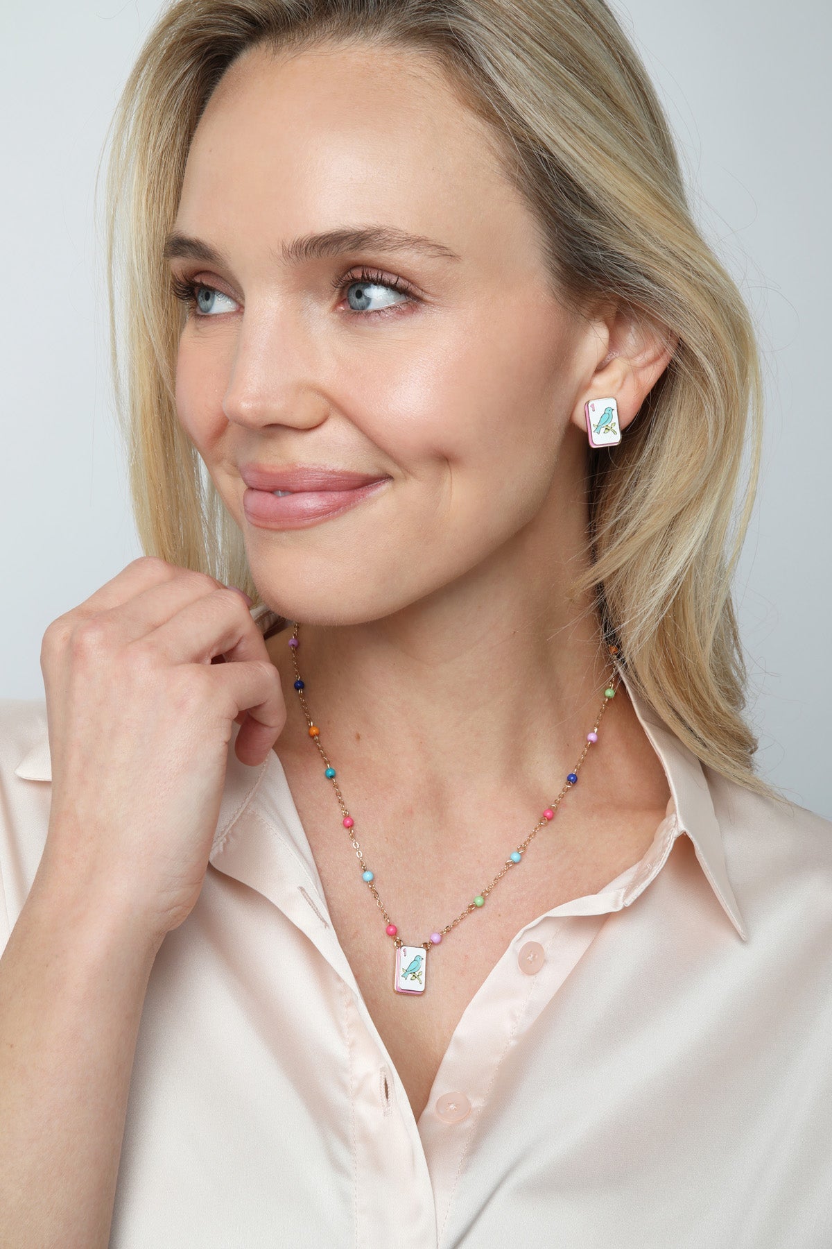 Model wearing white mahjong tile sparrow stud earrings with matching beaded necklace pendant