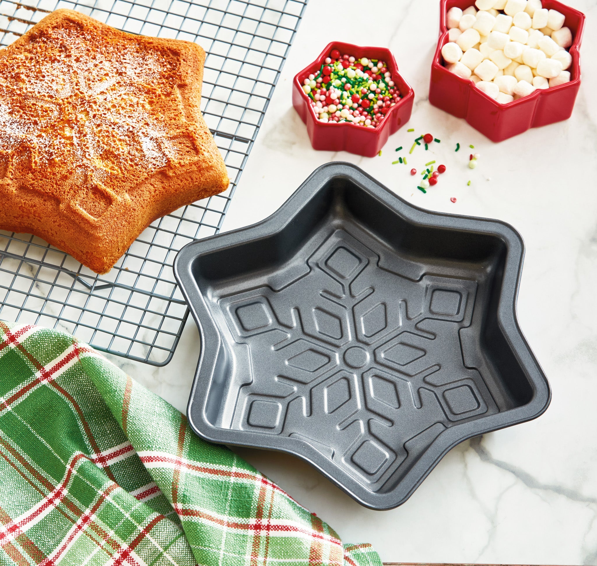 TAG 11-inch non-stick snowflake cake pan with baked snowflake cake on cooling rack