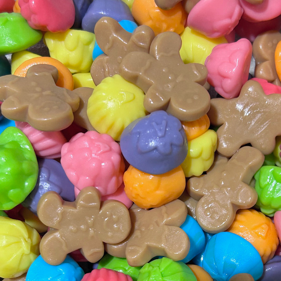 Close-up of colorful Christmas gumdrops and tan gingerbread man gummy candies mixed together