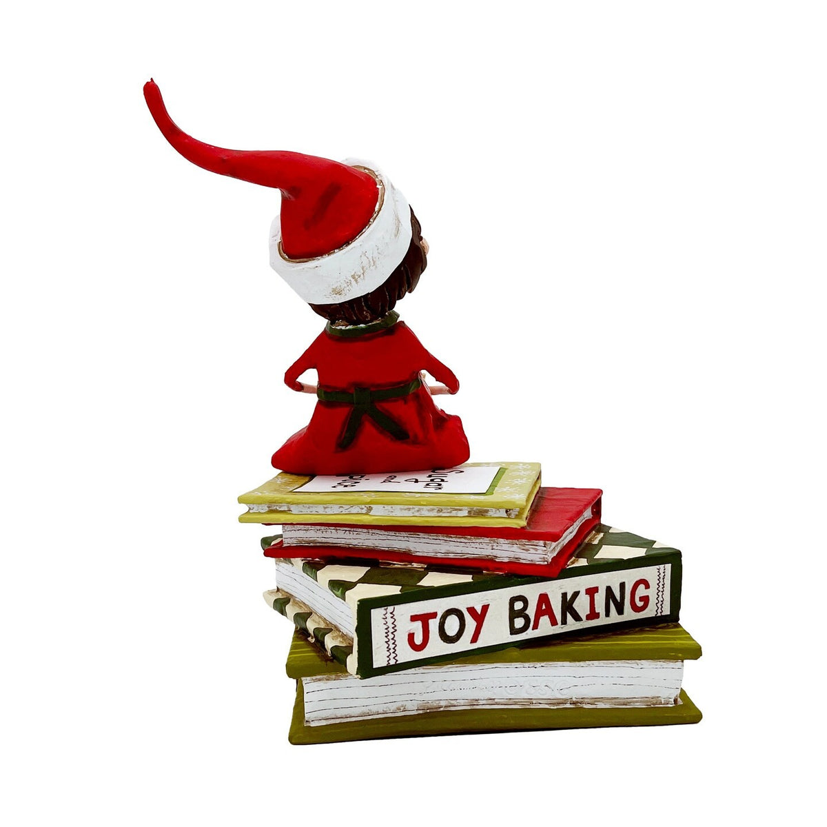 Back view of Sugar and Spice elf figurine sitting atop stacked holiday baking books