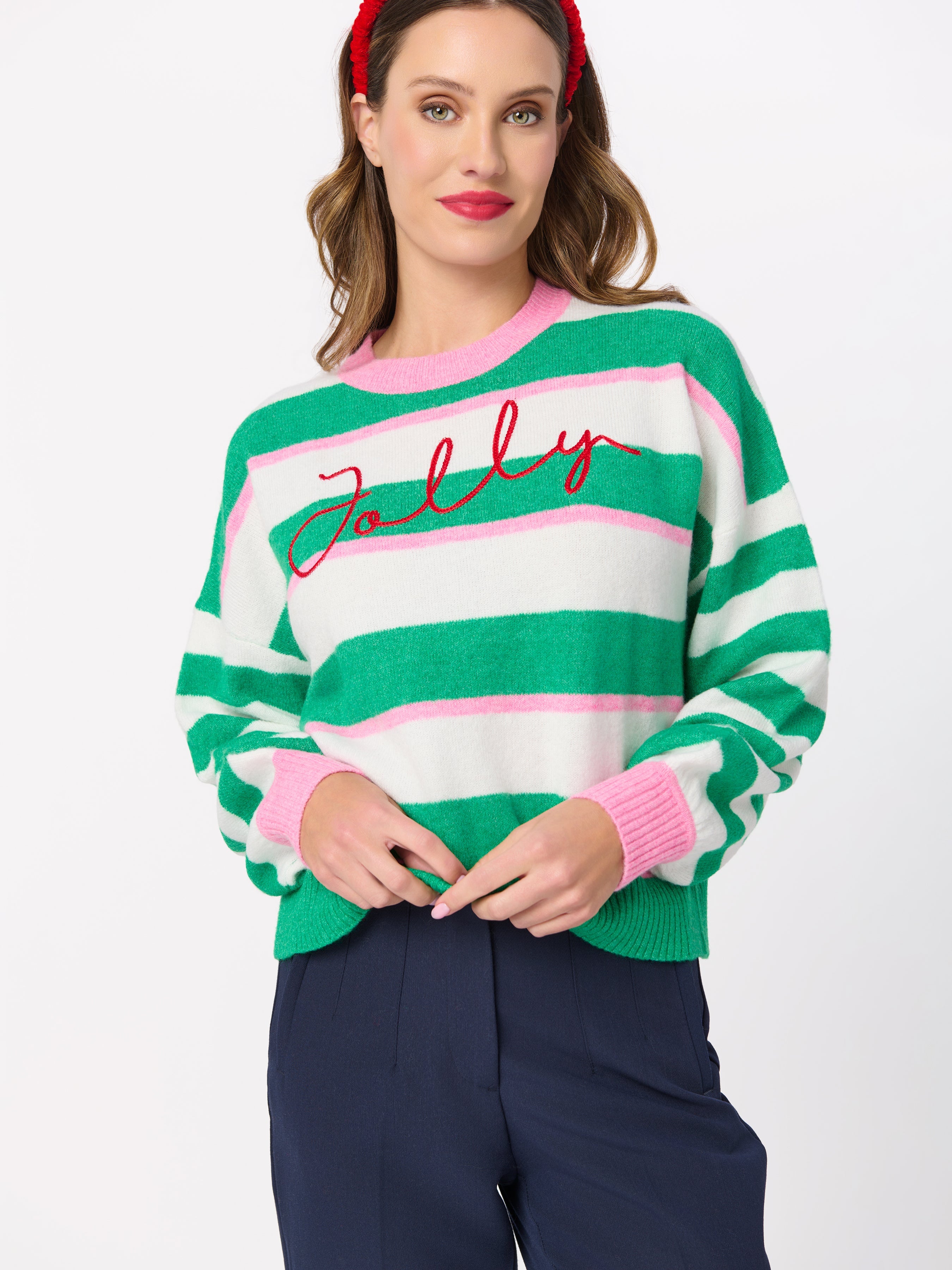 Model wearing green and white striped relaxed sweater with red Jolly script embroidery