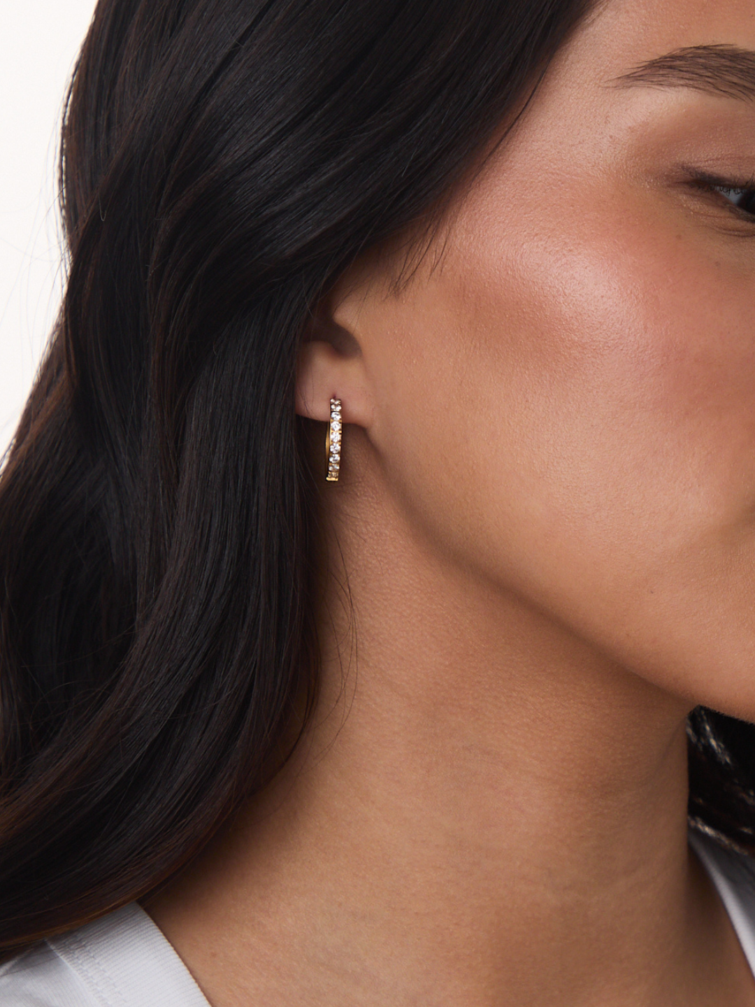 Model wearing Marrin Costello Jay Huggies Pave gold hoop earrings with pavé crystals