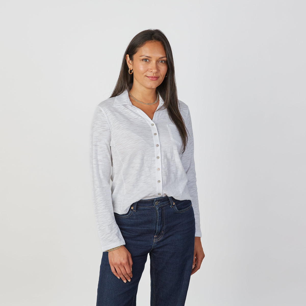 Woman wearing Erin Gray Alex Every Season Button Down Shirt in oyster white with dark jeans