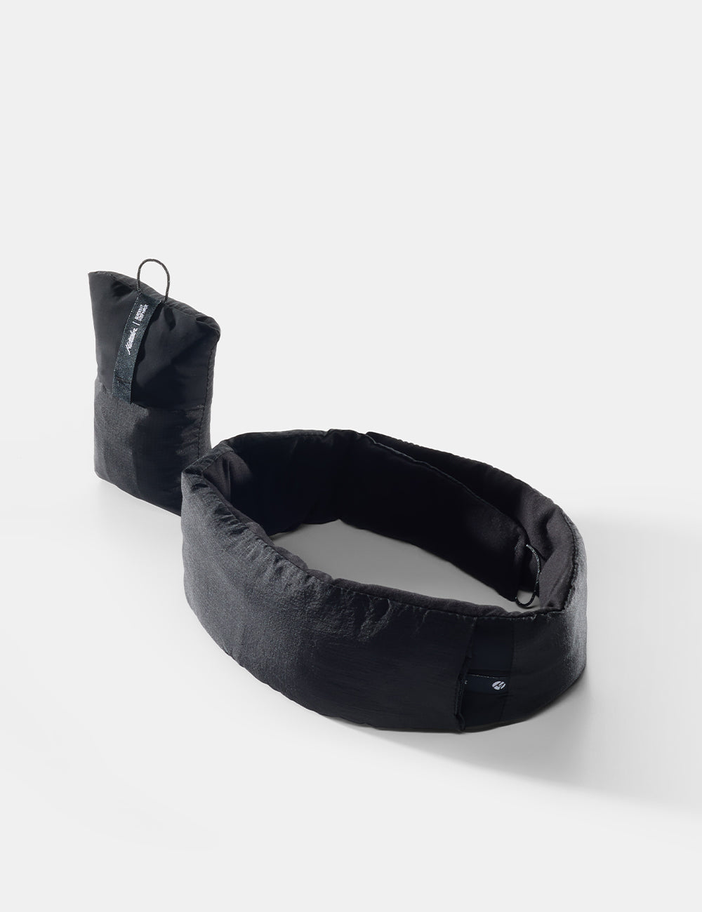 Matador blackout sleep mask unfolded with attached stuff sack pouch in black