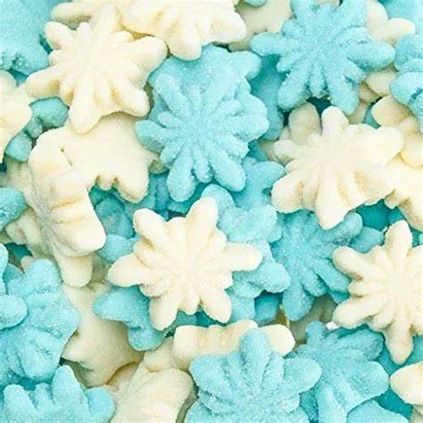 Blue and white sanded gummy snowflake candies piled together for Christmas holiday treats.