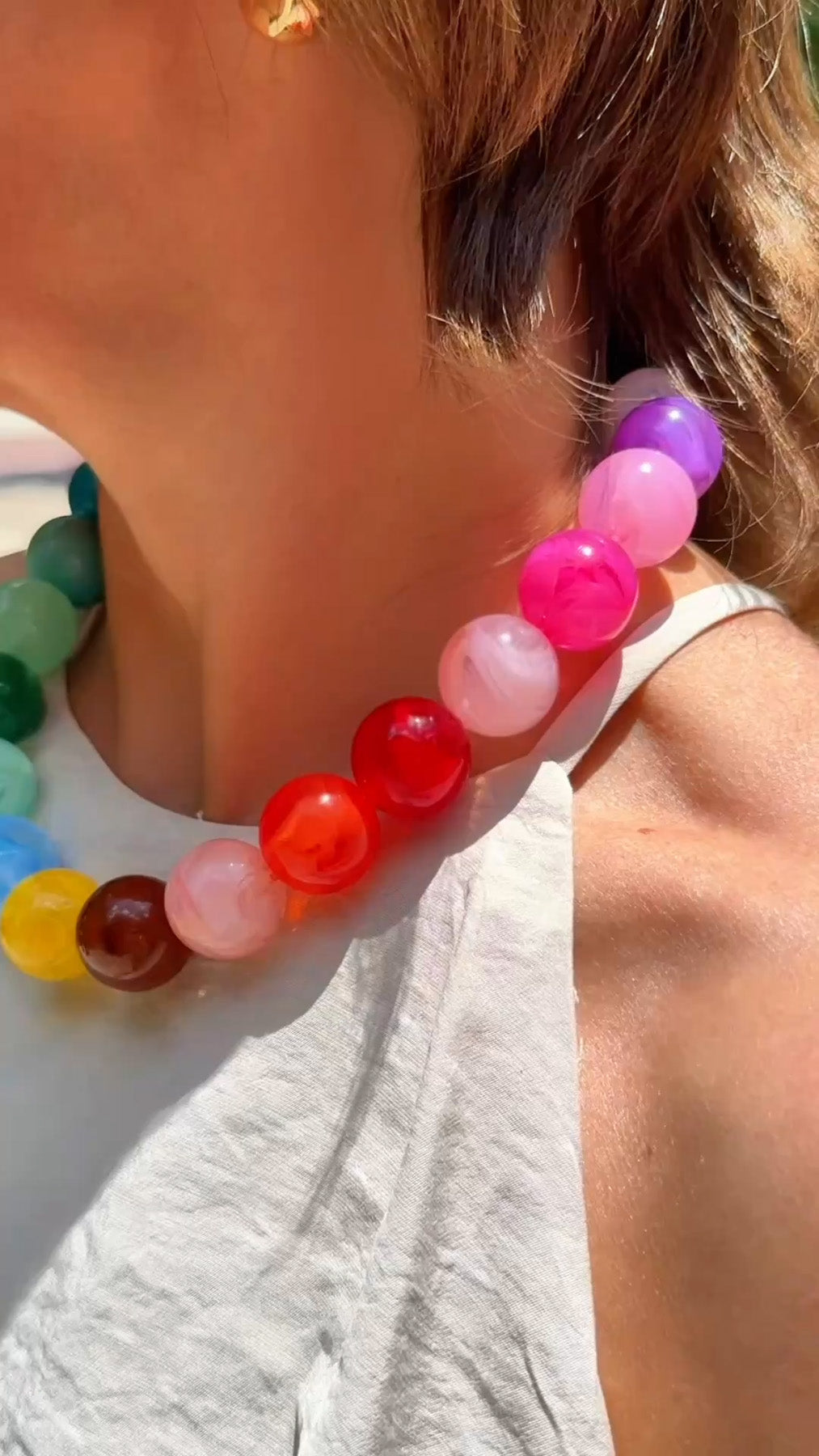 Close-up detail of rainbow multicolor large gumball beaded necklace worn on model