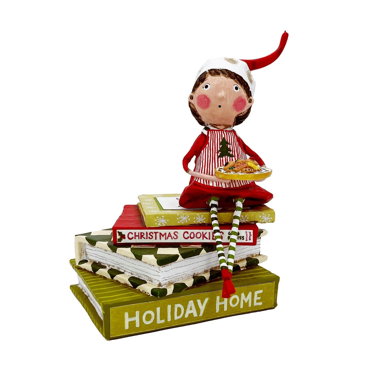 Lori Mitchell elf figurine holding cookie tray, seated atop stacked Christmas-themed books